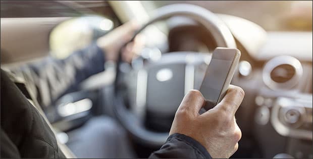 Distracted driver holding phone in hand