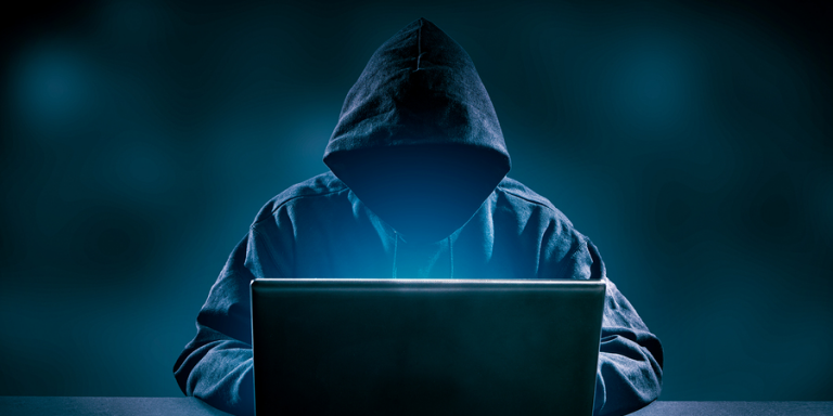 Dark figure with computer depicting scams