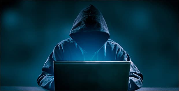 Dark figure with computer depicting scams